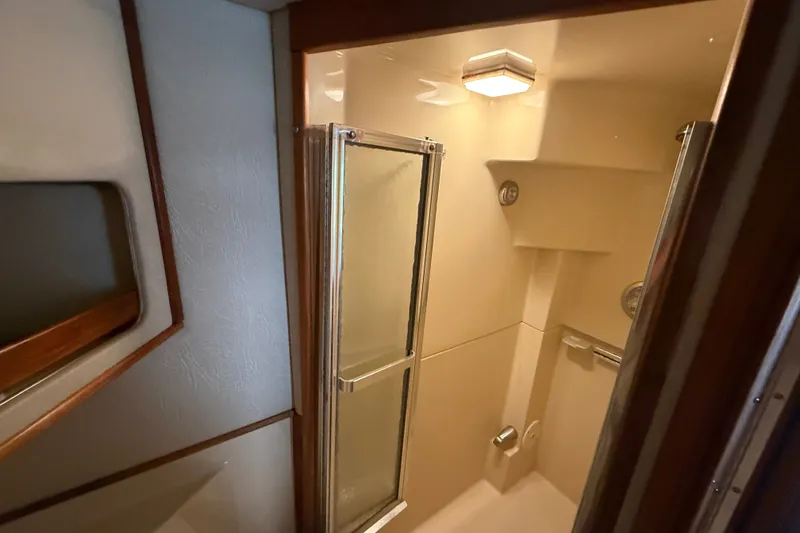 Slide: The Image of Shower area in 1986 Sea Ray 410 Aft Cabin yacht, featuring glass doors and modern lighting. - 49