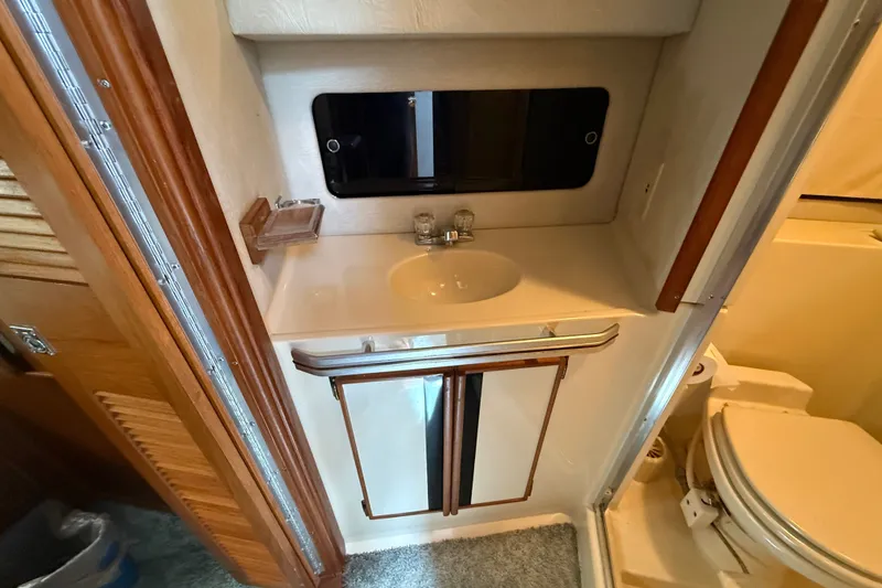 Slide: The Image of 1986 Sea Ray 410 Aft Cabin bathroom with sink, mirror, and toilet. - 40
