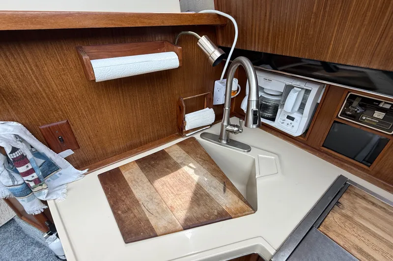 Slide: The Image of Compact kitchen area in a 1986 Sea Ray 410 Aft Cabin yacht with sink and appliances. - 31
