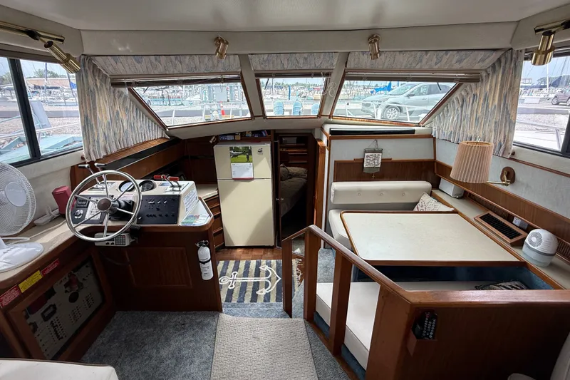 Slide: The Image of 1986 Sea Ray 410 Aft Cabin interior with helm, seating, and dining area. - 17