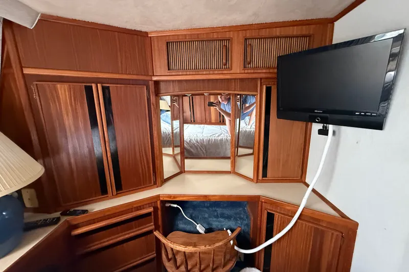 Slide: The Image of 1986 Sea Ray 410 Aft Cabin interior with wood cabinetry and mounted TV. - 45