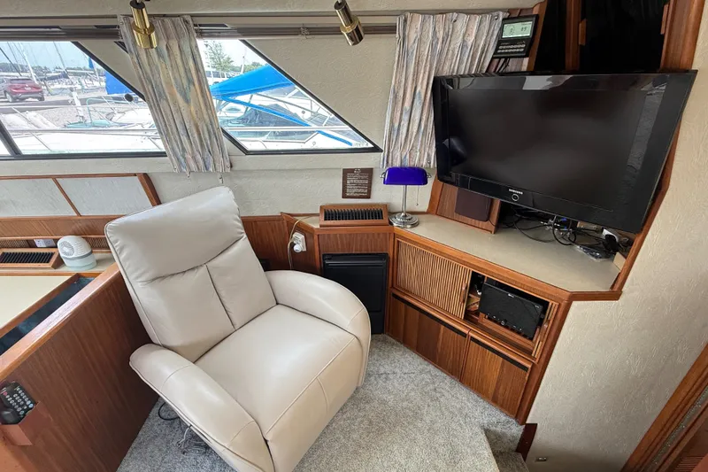 Slide: The Image of Interior of 1986 Sea Ray 410 Aft Cabin with recliner and TV setup. - 18
