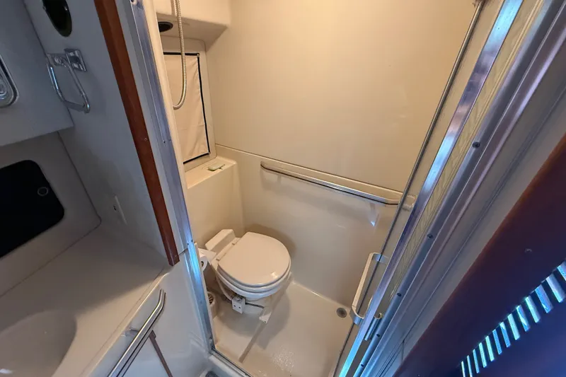 Slide: The Image of 1986 Sea Ray 410 Aft Cabin bathroom with toilet and shower. - 41