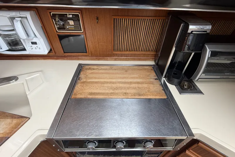 Slide: The Image of Galley kitchen in 1986 Sea Ray 410 Aft Cabin with appliances and wooden accents. - 30