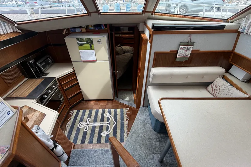 Slide: The Image of Interior of 1986 Sea Ray 410 Aft Cabin with kitchen and seating area. - 23
