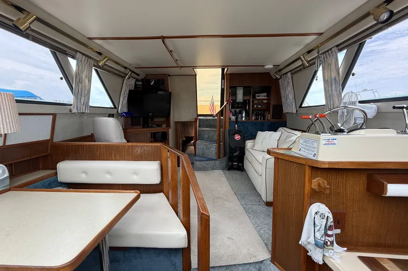 Slide: The Image of Interior of a 1986 Sea Ray 410 Aft Cabin yacht, featuring cozy seating and elegant wood finishes. - 27