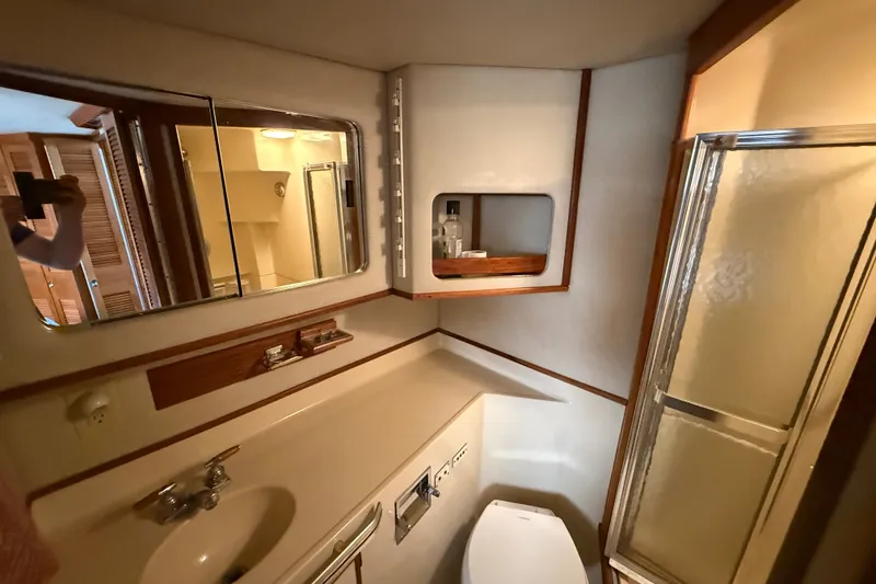 Slide: The Image of 1986 Sea Ray 410 Aft Cabin bathroom with sink, mirror, and shower. - 47