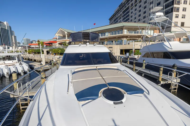 Slide: The Image of 2007 Neptunus 62 Flybridge yacht docked at a marina with cityscape background. - 46