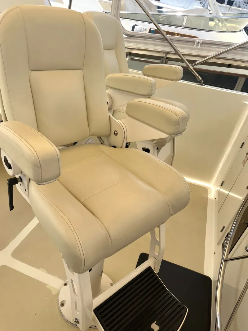 Slide: The Image of Two cushioned captain's chairs with armrests on a yacht, surrounded by stainless steel railings. - 43