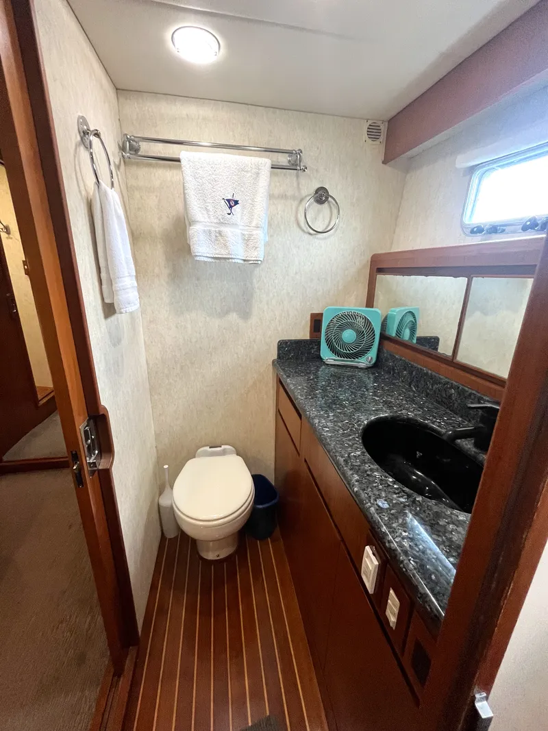 Slide: The Image of The image shows a boat bathroom with a toilet, sink, and towel rack. - 35
