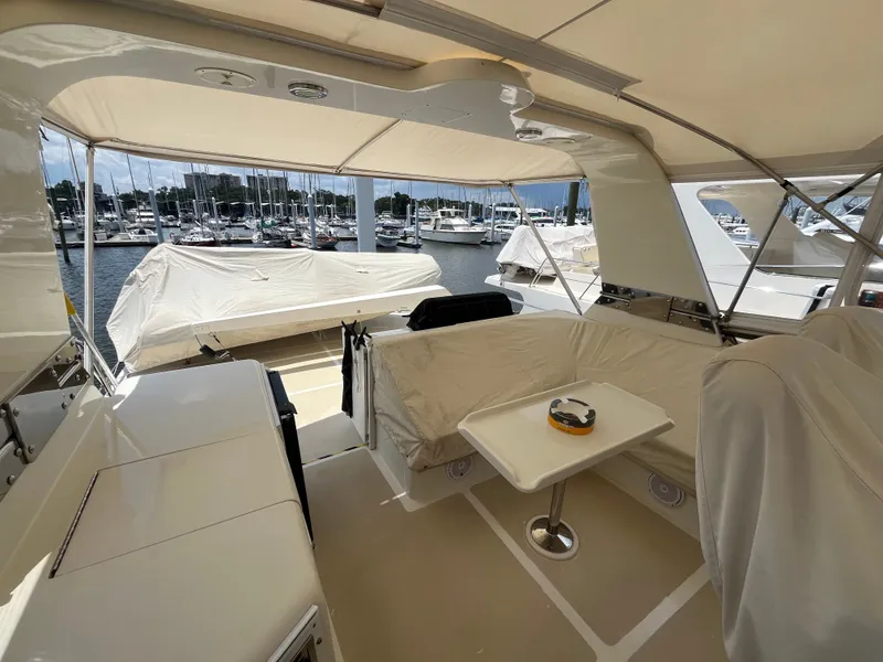 Slide: The Image of The image shows the covered aft deck of a 2002 Grand Alaskan 53 RPH, featuring seating and a table. - 45