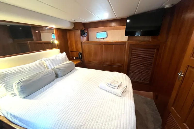 Slide: The Image of The cabin of a 2002 Grand Alaskan 53 RPH with a cozy bed and a television. - 32