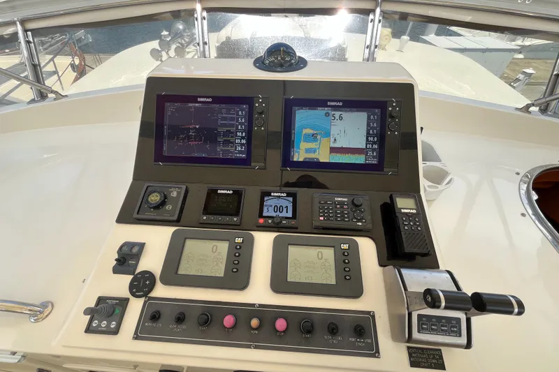 Slide: The Image of The image shows the helm of a 2002 Grand Alaskan 53 RPH with multiple screens and controls. - 42