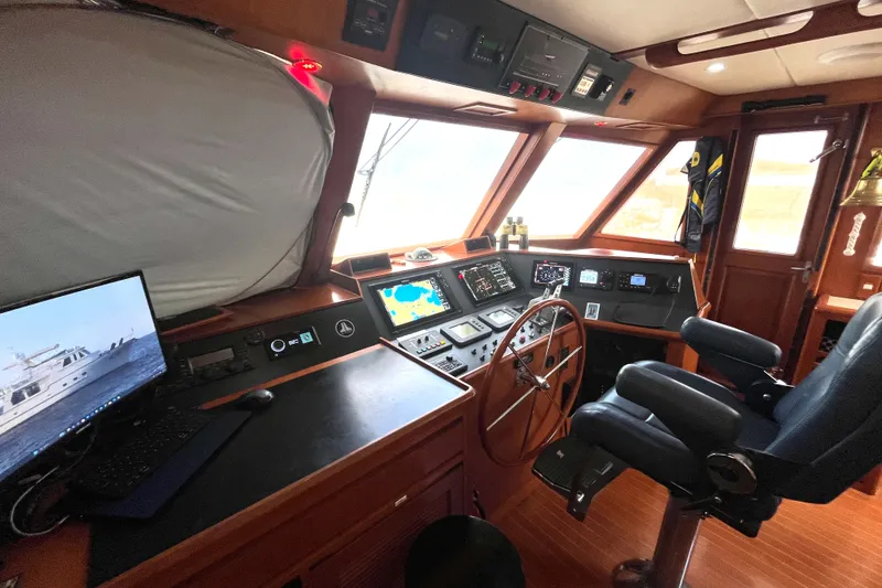 Slide: The Image of Helm of a 2002 Grand Alaskan 53 RPH with modern navigation equipment and a comfortable chair. - 18