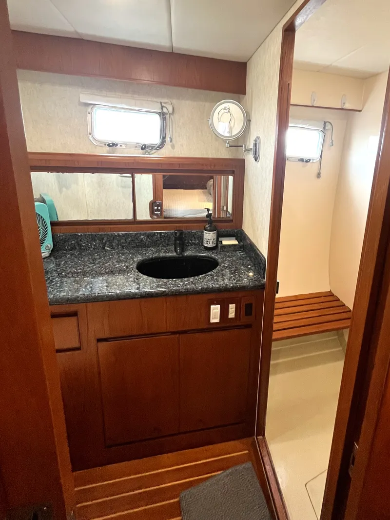 Slide: The Image of The image shows a boat bathroom with a sink, mirror, and wooden cabinetry. - 34