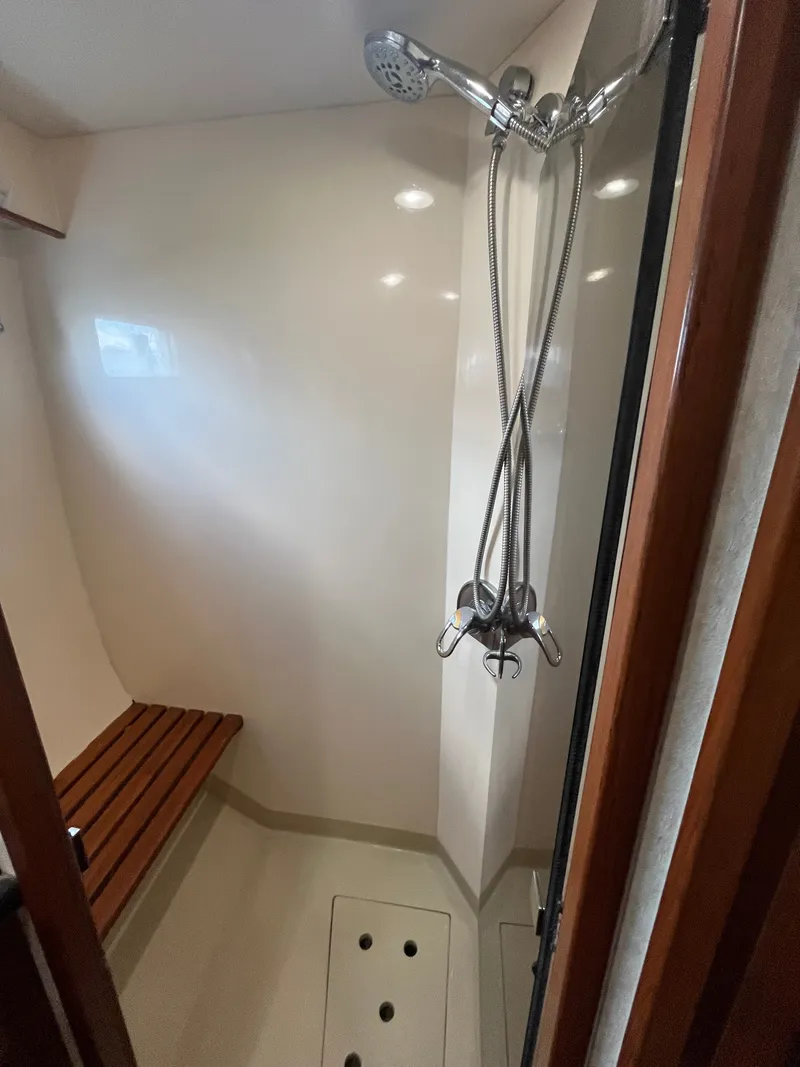 Slide: The Image of The 2002 Grand Alaskan 53 RPH shower features a wooden bench and a handheld showerhead. - 36
