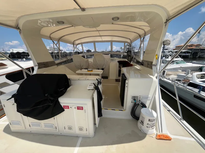 Slide: The Image of The image shows the covered deck of a 2002 Grand Alaskan 53 RPH at a marina. - 46