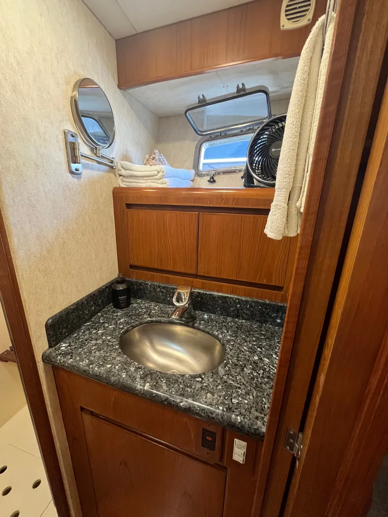 Slide: The Image of A sleek bathroom with wooden cabinets, a round sink, and a small window. - 30