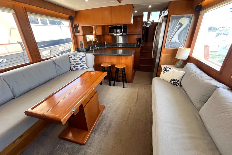 Slide: The Image of The interior of a 2002 Grand Alaskan 53 RPH features a cozy seating area and a well-equipped kitchen. - 4