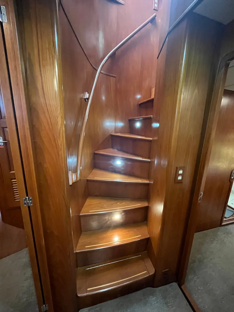 Slide: The Image of An elegant wooden staircase with a curved railing in a boat, surrounded by warm wood paneling. - 37