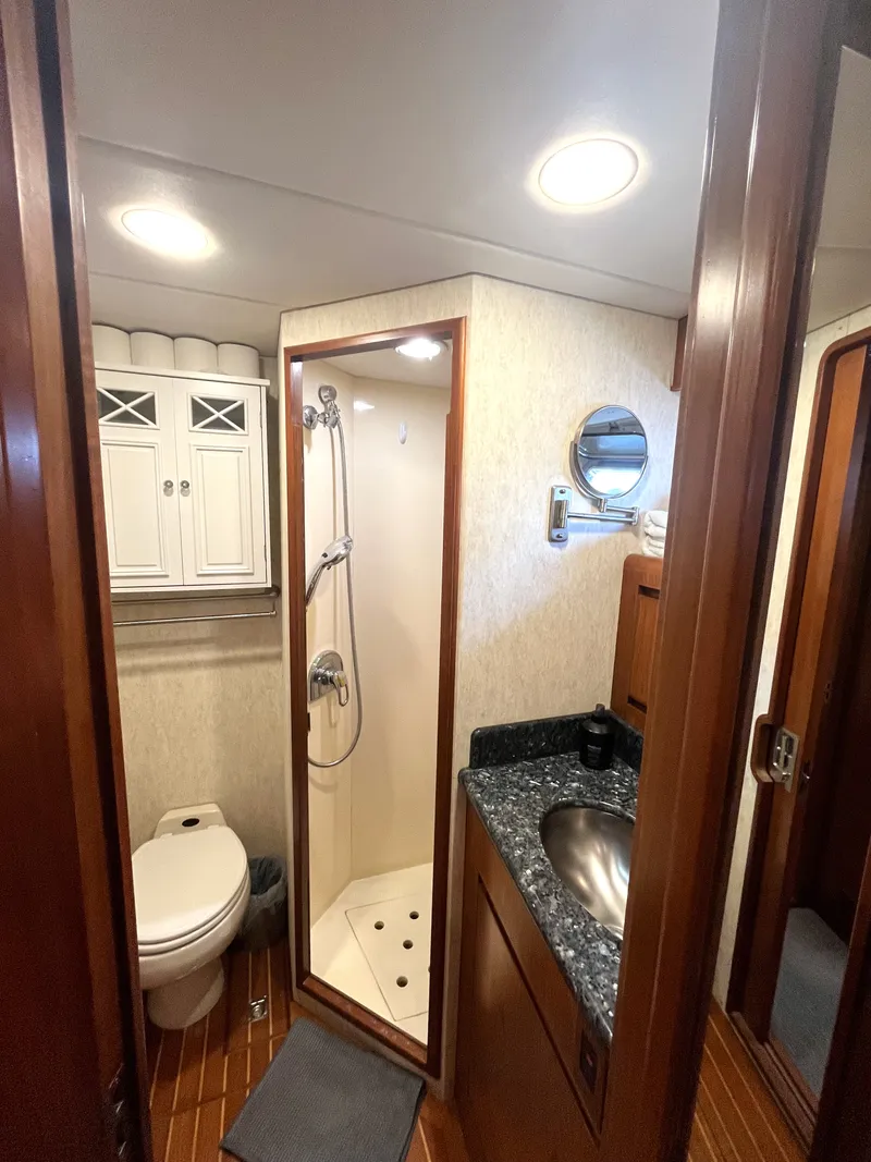 Slide: The Image of The image shows a boat bathroom with a shower, sink, and toilet. - 29