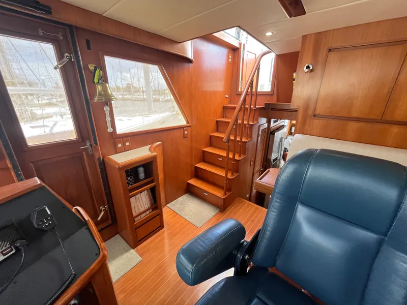 Slide: The Image of Interior of a 2002 Grand Alaskan 53 RPH with wood paneling, stairs, and a leather chair. - 22