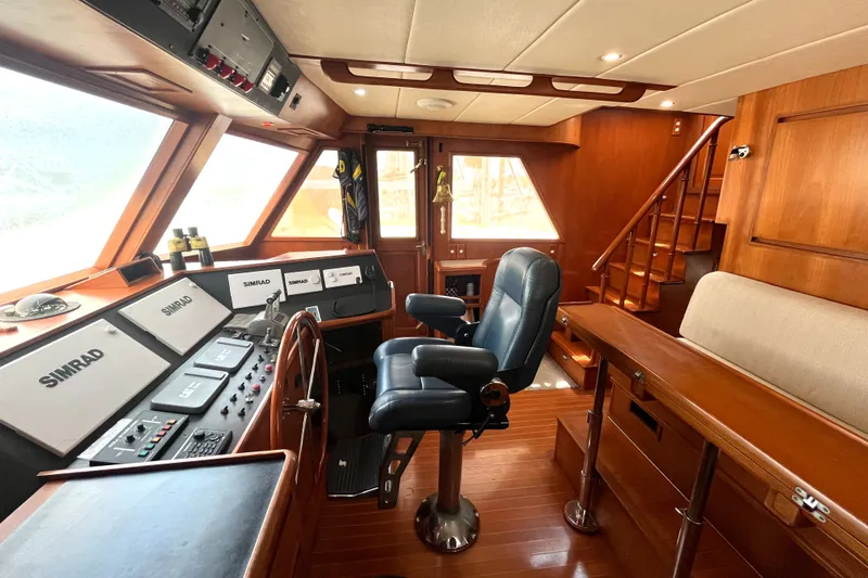 Slide: The Image of The image shows the helm of a 2002 Grand Alaskan 53 RPH with wood finishes and modern electronics. - 38