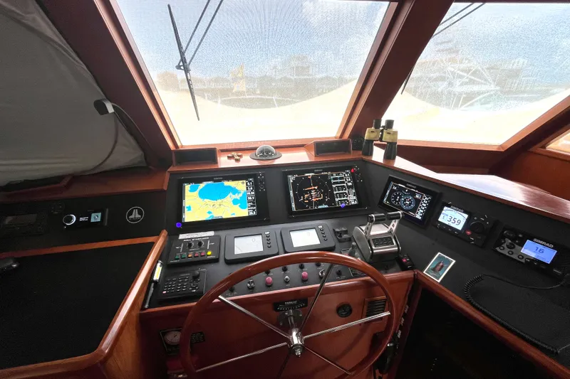 Slide: The Image of The image shows the helm of a 2002 Grand Alaskan 53 RPH with modern navigation instruments. - 17