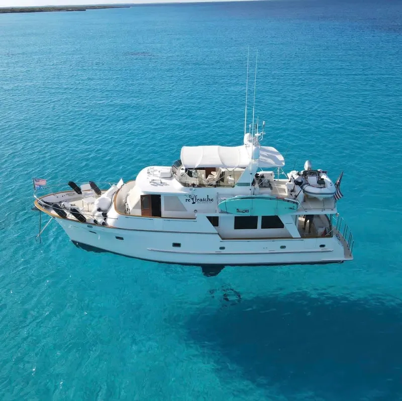 Slide: The Image of A 2002 Grand Alaskan 53 RPH yacht on clear, blue water. - 2