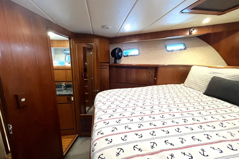 Slide: The Image of The 2002 Grand Alaskan 53 RPH cabin features a cozy bed and wooden walls. - 27