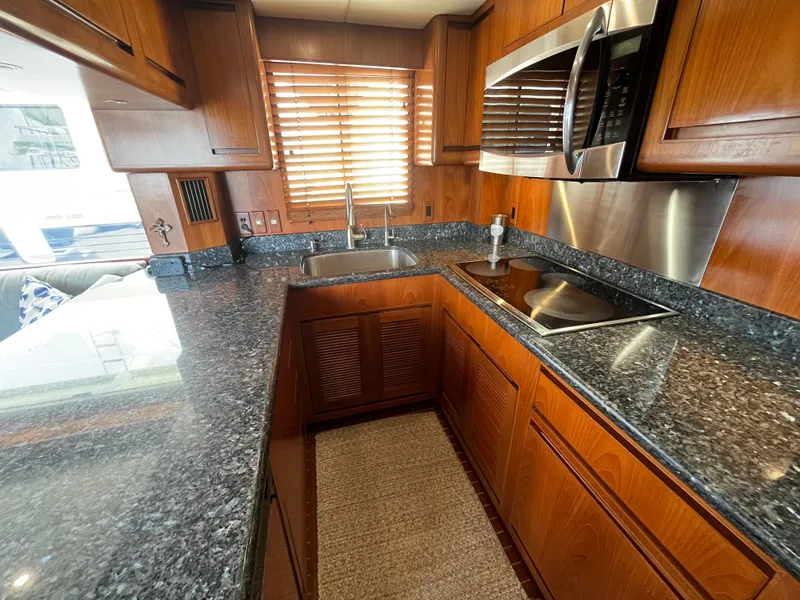 Slide: The Image of The 2002 Grand Alaskan 53 RPH kitchen features granite countertops and wooden cabinetry. - 9