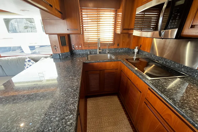 Slide: The Image of The 2002 Grand Alaskan 53 RPH kitchen features granite countertops and wooden cabinets. - 10