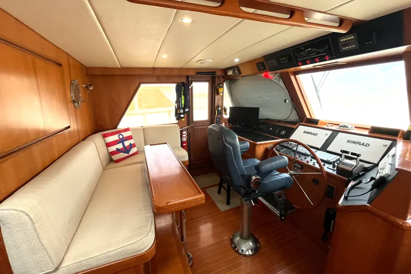 Slide: The Image of Interior of a 2002 Grand Alaskan 53 RPH with helm, seating, and wood finish. - 13