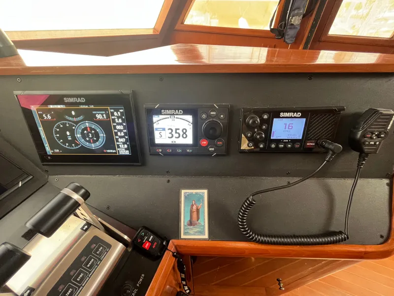 Slide: The Image of The image shows the helm of a 2002 Grand Alaskan 53 RPH with Simrad electronics. - 19