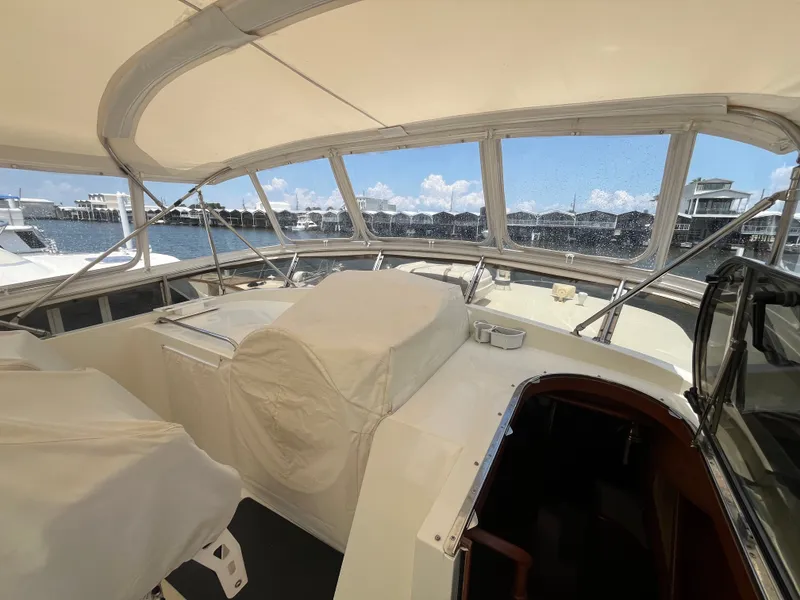 Slide: The Image of The image shows the covered helm of a 2002 Grand Alaskan 53 RPH with a view of the marina. - 39