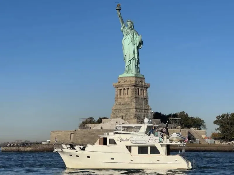Slide: The Image of A 2002 Grand Alaskan 53 RPH yacht cruises past the Statue of Liberty. - 1