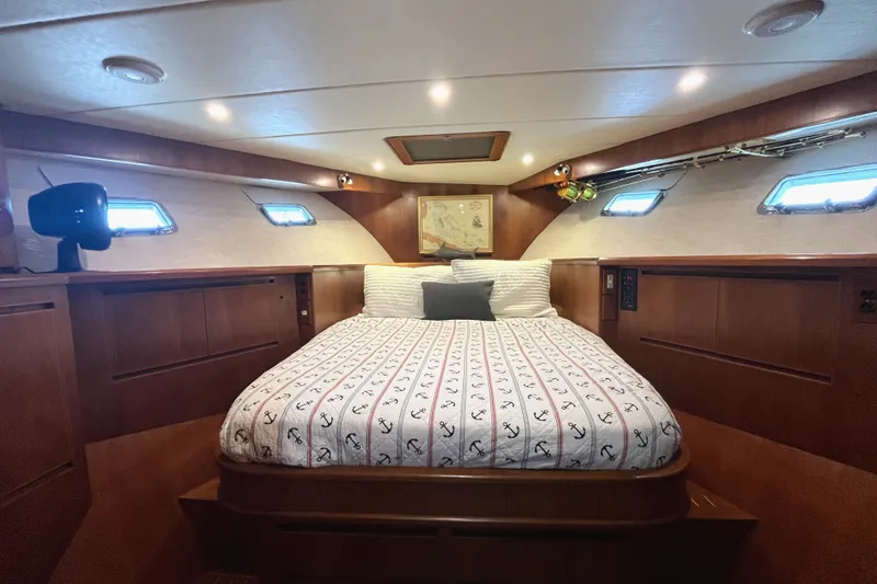 Slide: The Image of The cabin of a 2002 Grand Alaskan 53 RPH with a cozy double bed and wooden furnishings. - 25