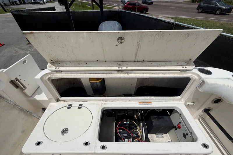 Slide: The Image of 2019 Robalo R222 Center Console boat storage compartment with open hatch and visible wiring. - 64