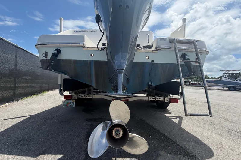 Slide: The Image of 2019 Robalo R222 Center Console boat on trailer, rear view with propeller and ladder. - 4