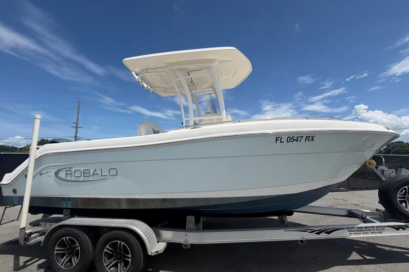Slide: The Image of 2019 Robalo R222 Center Console boat on trailer under clear blue sky. - 1