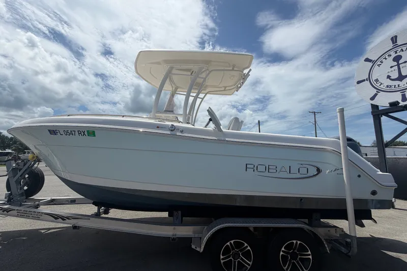 Slide: The Image of 2019 Robalo R222 Center Console boat on trailer under cloudy sky. - 8