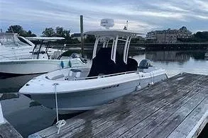 Slide: The Image of 2019 Robalo R222 Center Console boat docked at a marina, overcast sky. - 2