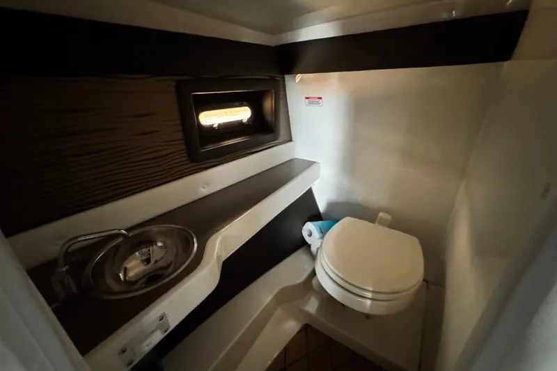 Slide: The Image of 2022 Sea Ray SLX 280 boat bathroom with sink, toilet, and window. - 19