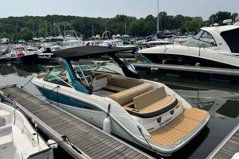 Slide: The Image of 2022 Sea Ray SLX 280 boat docked at a marina with other vessels. - 4