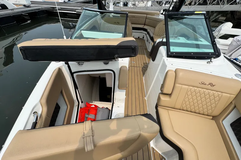 Slide: The Image of 2022 Sea Ray SLX 280 boat interior with tan seating and open storage compartment. - 16