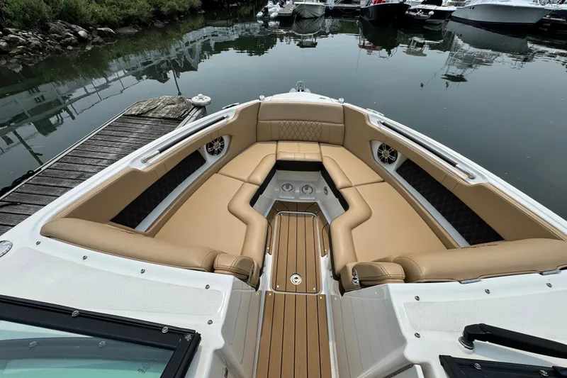 Slide: The Image of Luxurious 2022 Sea Ray SLX 280 boat interior with tan seating at a dock. - 14