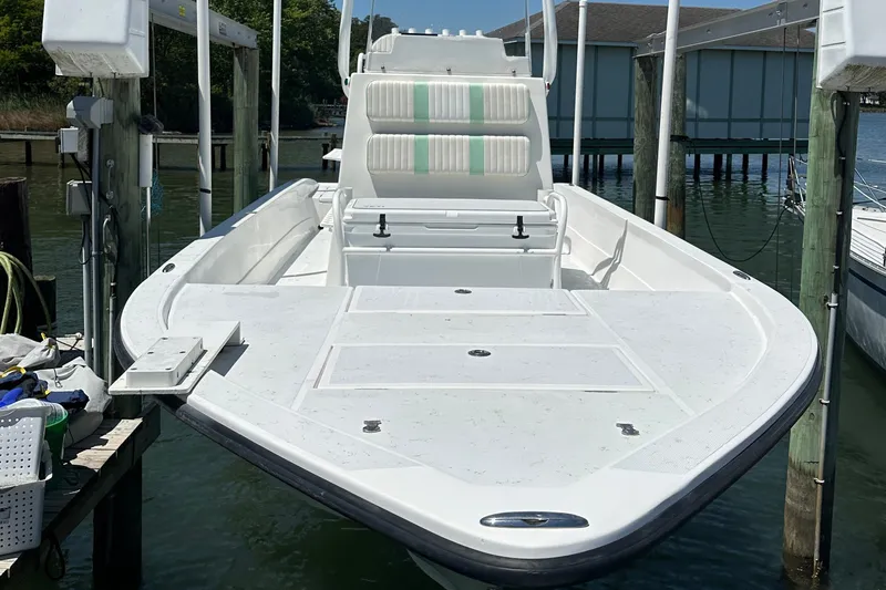 Slide: The Image of 2016 Shallow Sport 24 Modified V boat docked, featuring spacious deck and seating. - 29