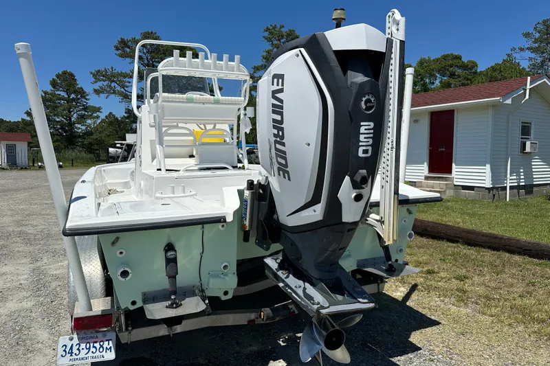 Slide: The Image of 2016 Shallow Sport 24 Modified V boat with Evinrude outboard motor, parked outdoors. - 17