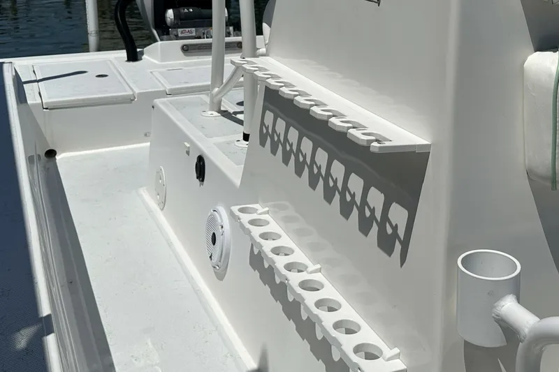 Slide: The Image of 2016 Shallow Sport 24 Modified V boat interior with rod holders and storage compartments. - 28
