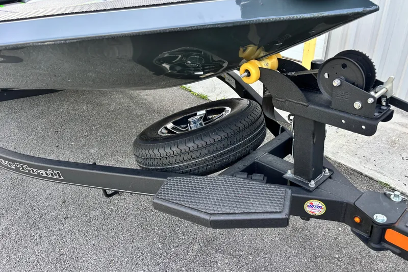 Slide: The Image of 2025 Ranger RT198P boat trailer with winch and spare tire on asphalt. - 2
